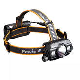 Fenix headlamp with black and orange strap on a white background