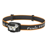 Fenix headlamp with orange and black strap on a white background