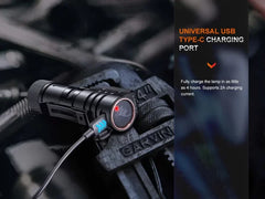 Black flashlight with USB charging port on a dark background